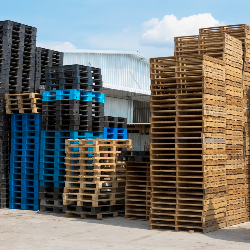 Stack of new 48 x 40 wood pallets and plastic pallets in various colors